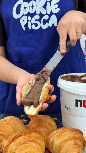 Croissant sendo recheado com creme de avelã